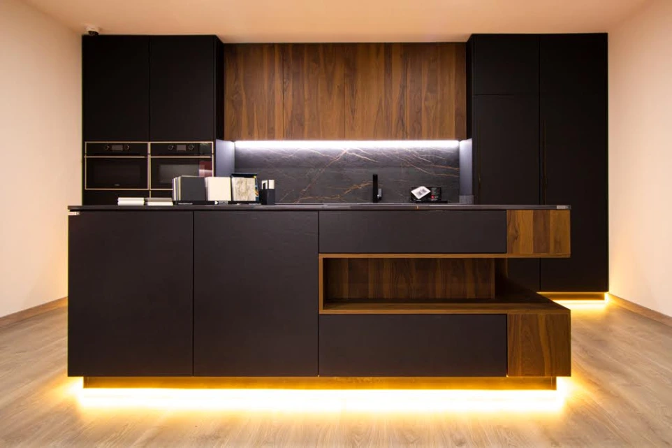 Cozinha moderna com armários em madeira escura e iluminação suspensa